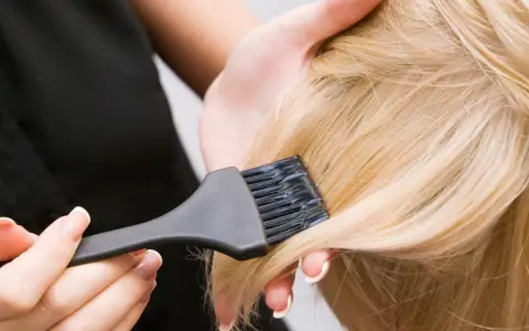 Delikatne włosy blond i pędzel do farbowania. Po rozjaśnianiu skóra głowy może być podrażniona, dlatego ważne jest odpowiednie pielęgnowanie.