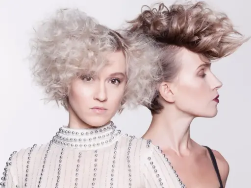 Dwie kobiety z ekstrawaganckimi fryzurami, inspirowanymi kemon hair manya. Jedna z przodu, druga z profilu, obie w artystycznych stylizacjach.